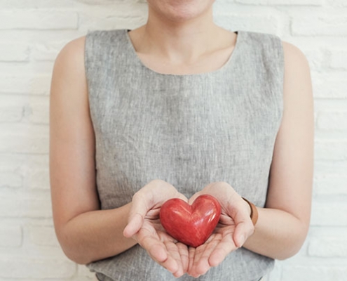 woman holding fake heart for her healthy goals